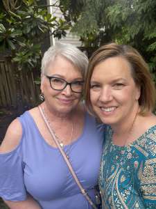 Older and younger woman close together smiling